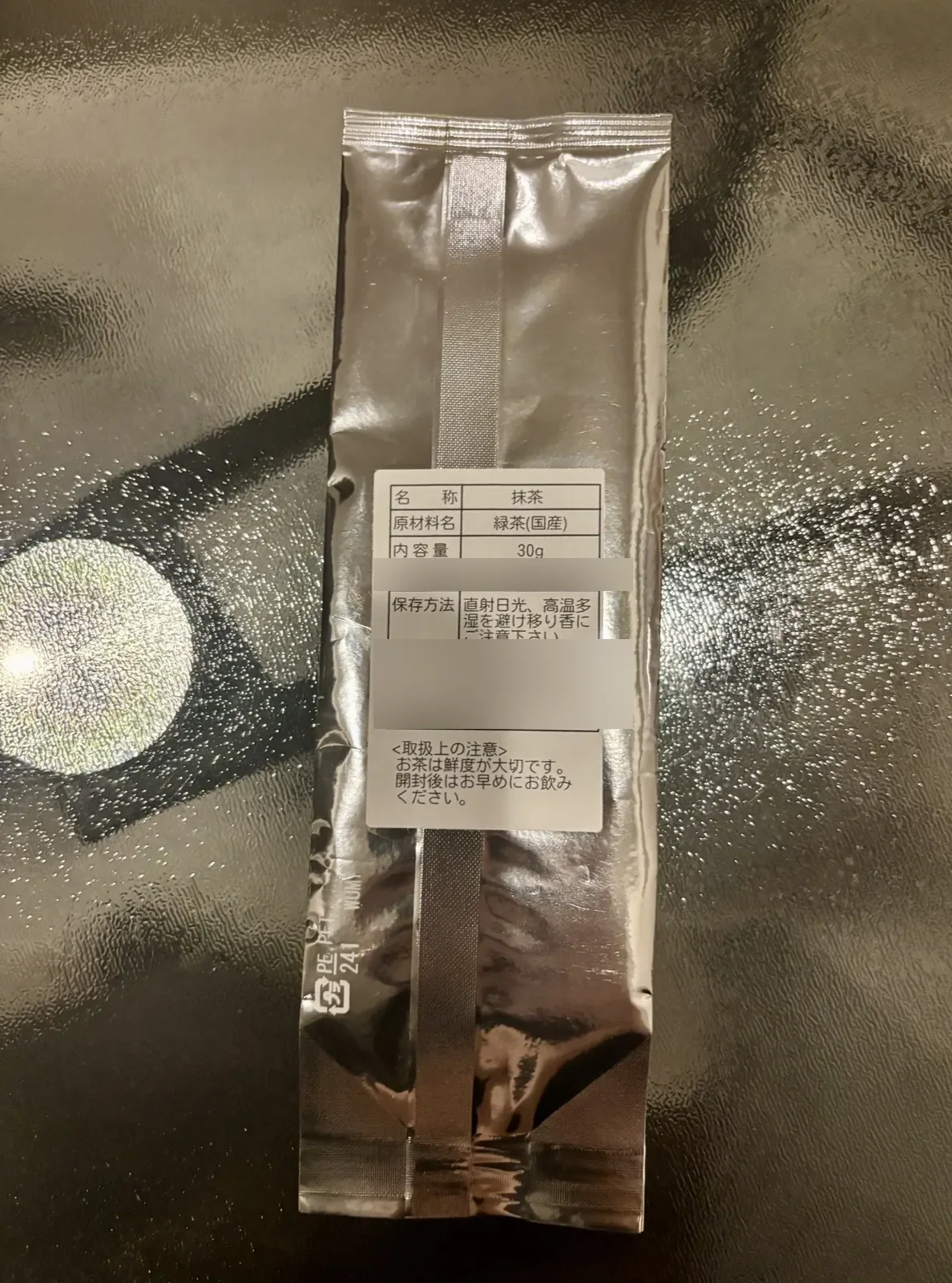 A 30 gram pouch of Japanese matcha with its Japanese label listing product name, ingredient and net weight.
