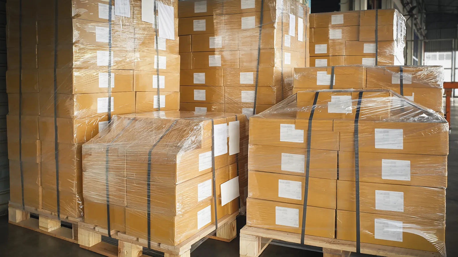 Wrapped and labelled cartons stacked on pallets in a warehouse.