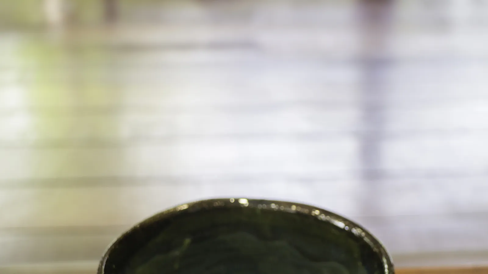 A bowl of whisked matcha showing its colour and surface