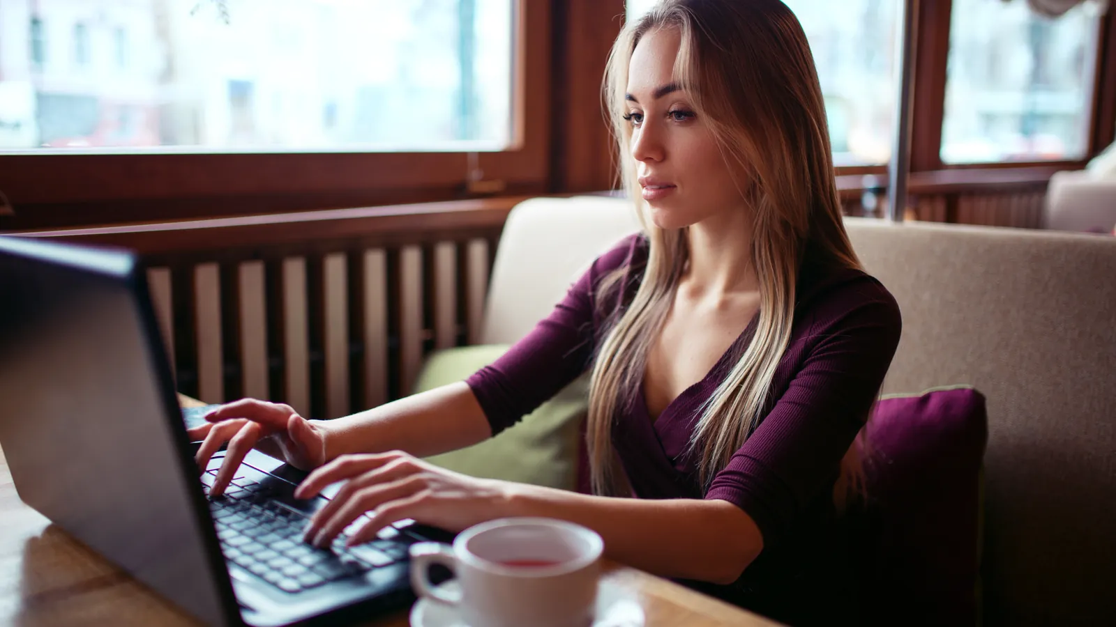 A customer working on a laptop at a cafe table