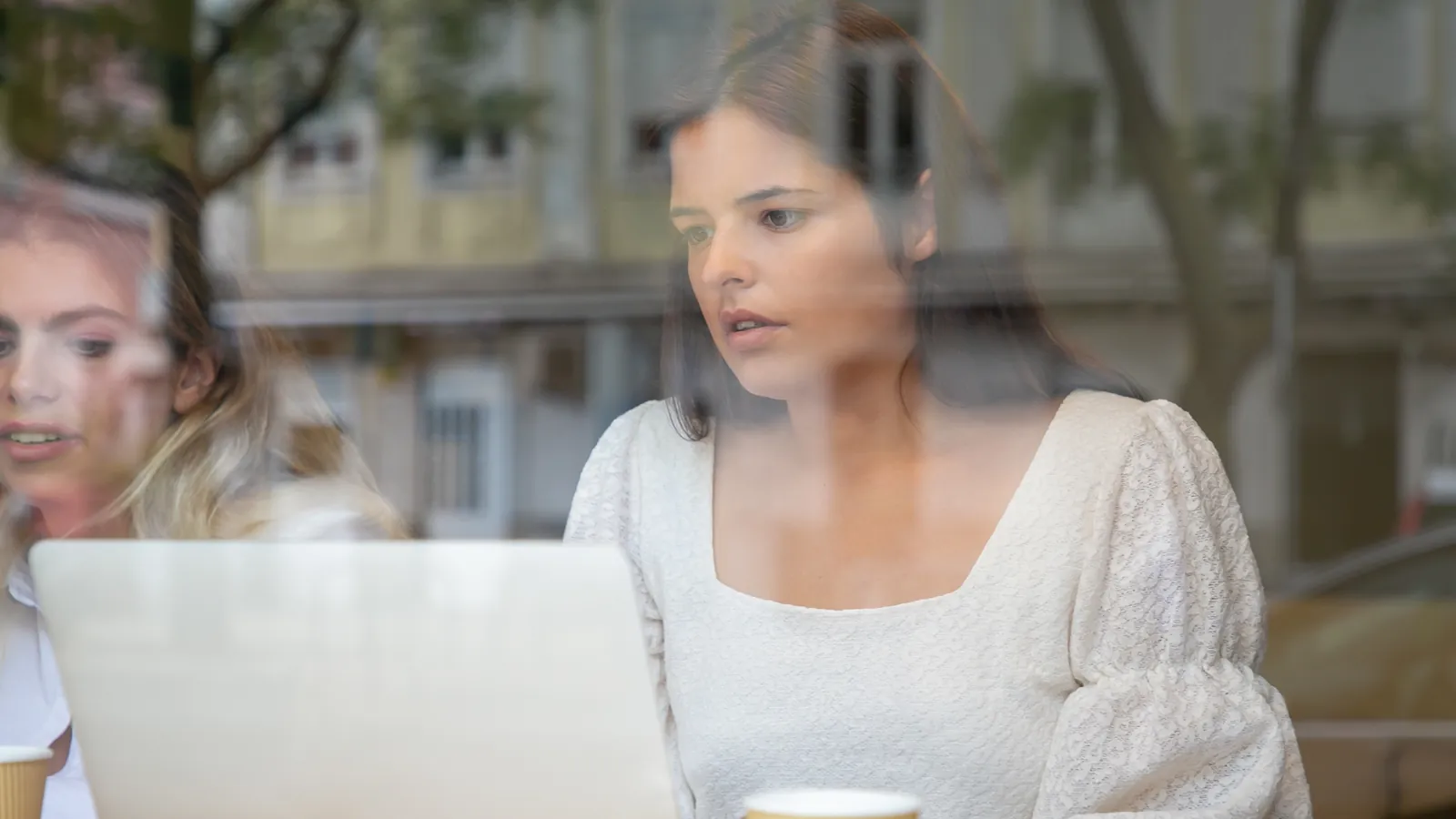Two people talking across a table in a cafe