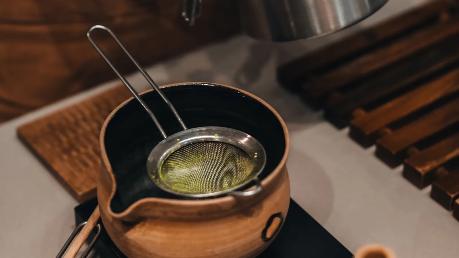 Matcha, a whisk and a scoop arranged on a work surface