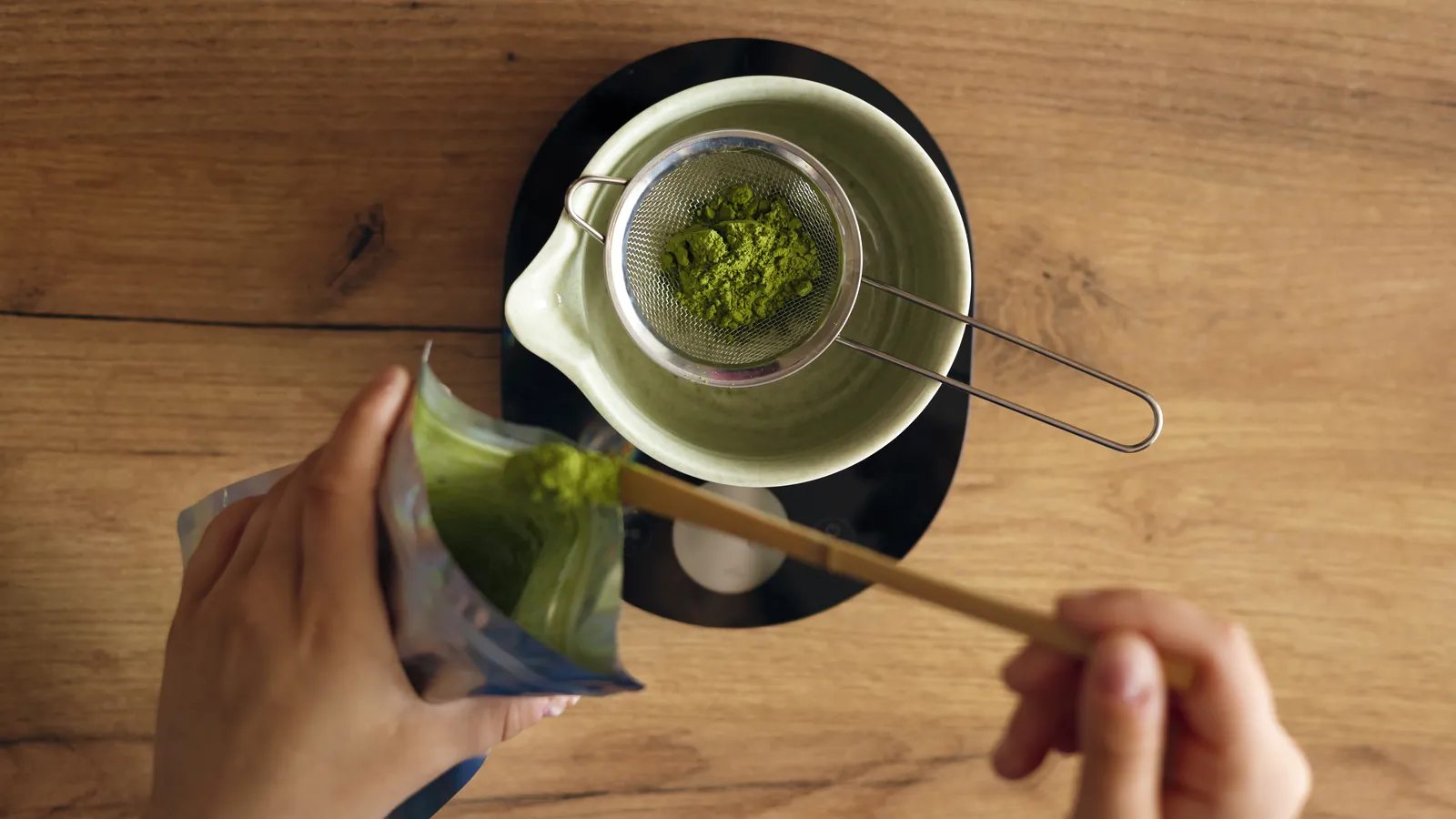 Matcha being sifted into a bowl, seen from above