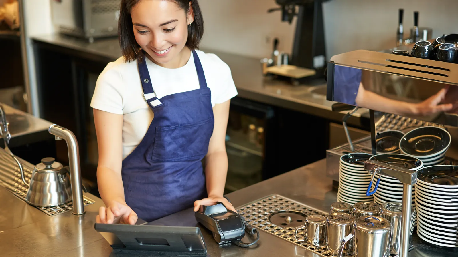 A barista taking an order at a cafe till
