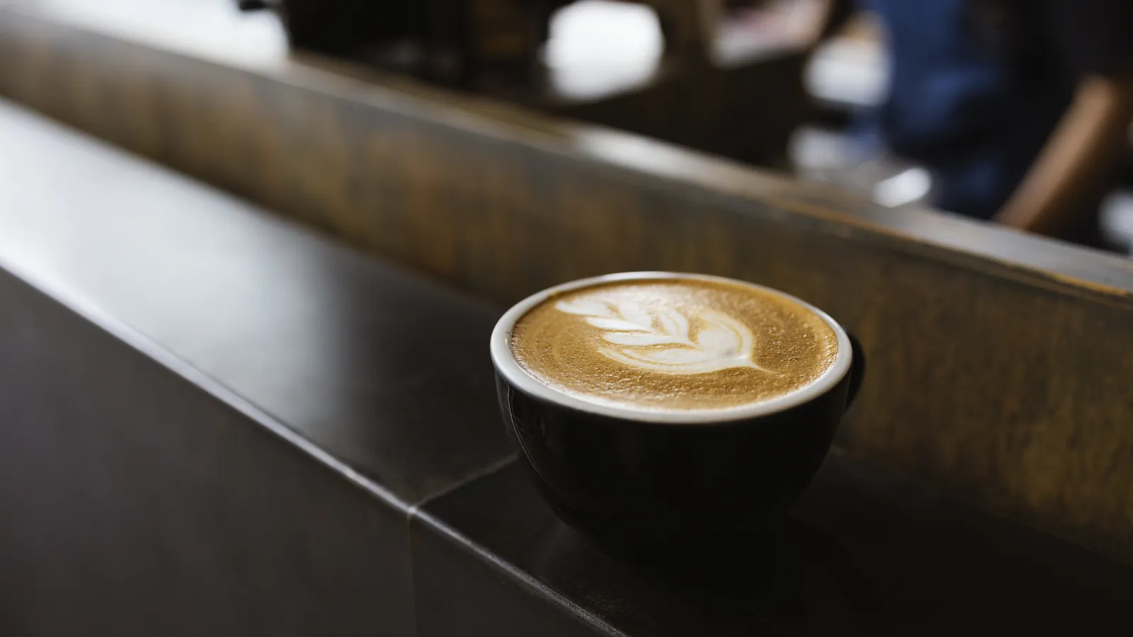 A finished drink waiting on a cafe counter in soft daylight