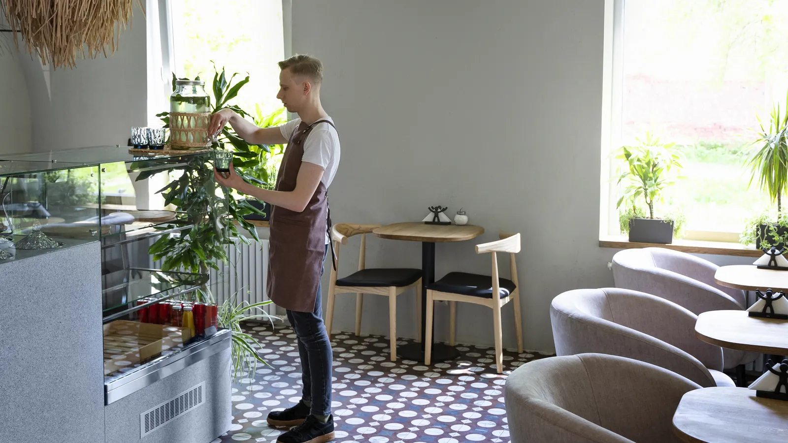 A cafe owner tidying the room between services