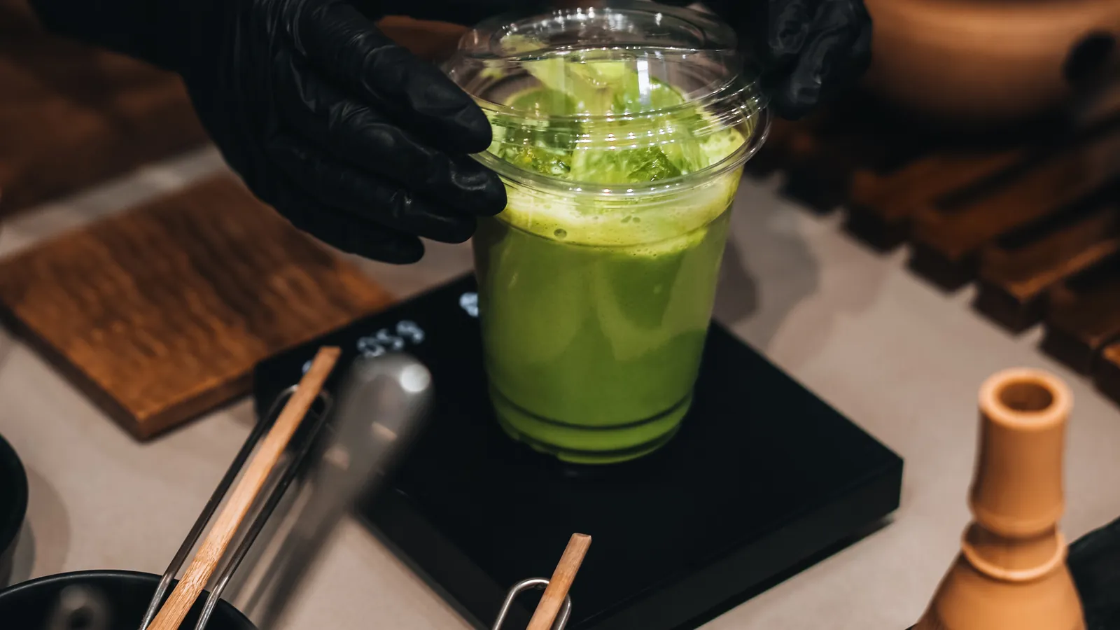 Hands preparing matcha with traditional utensils