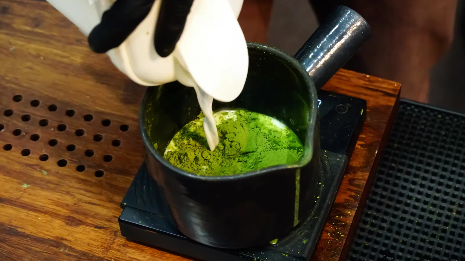 Matcha being weighed on a bar scale before whisking