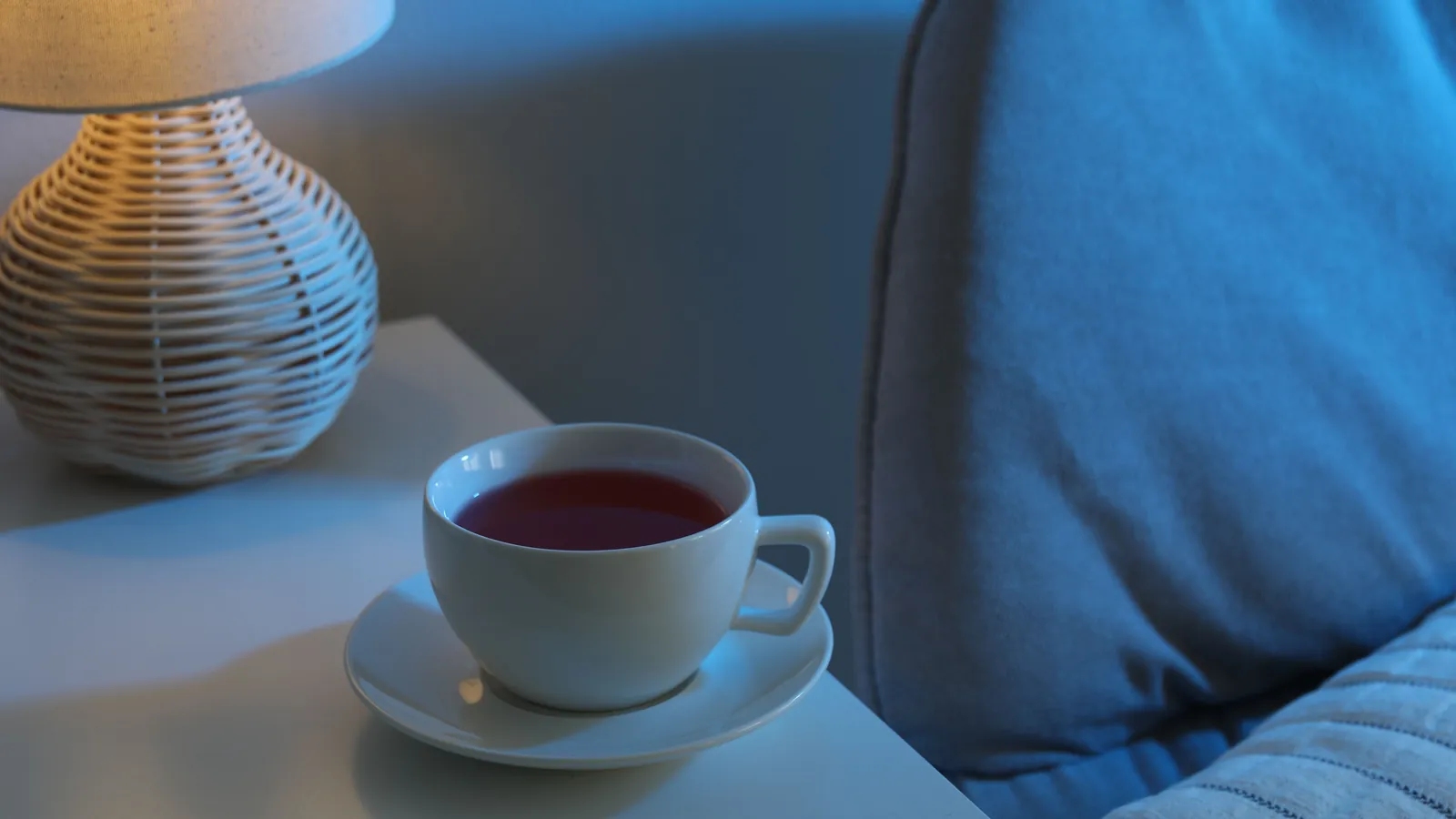 A hot drink beside a lamp late in the evening