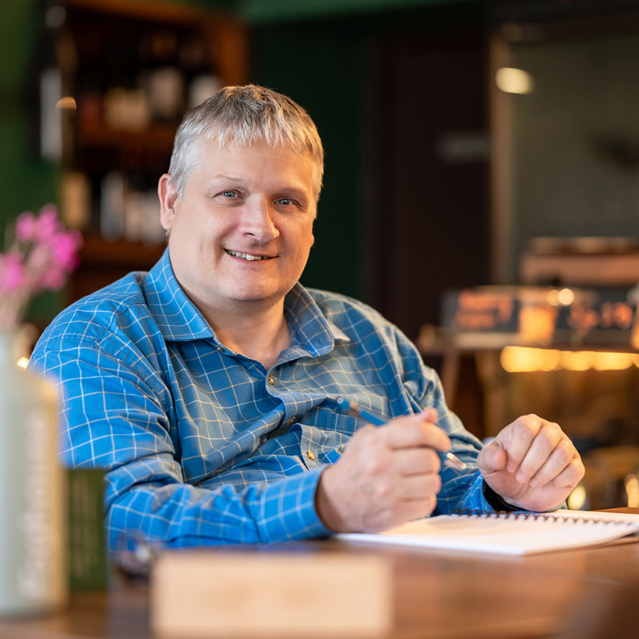 Gordon sitting at a table with pen in hand and a notebook