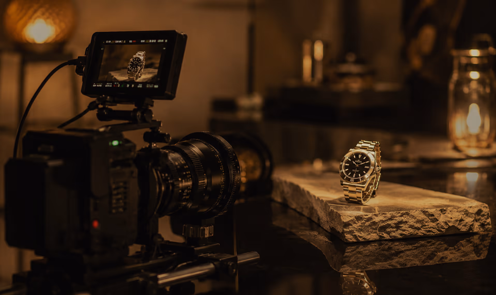 Professional cinema camera filming a luxury watch product shoot in a warm, moody studio setting