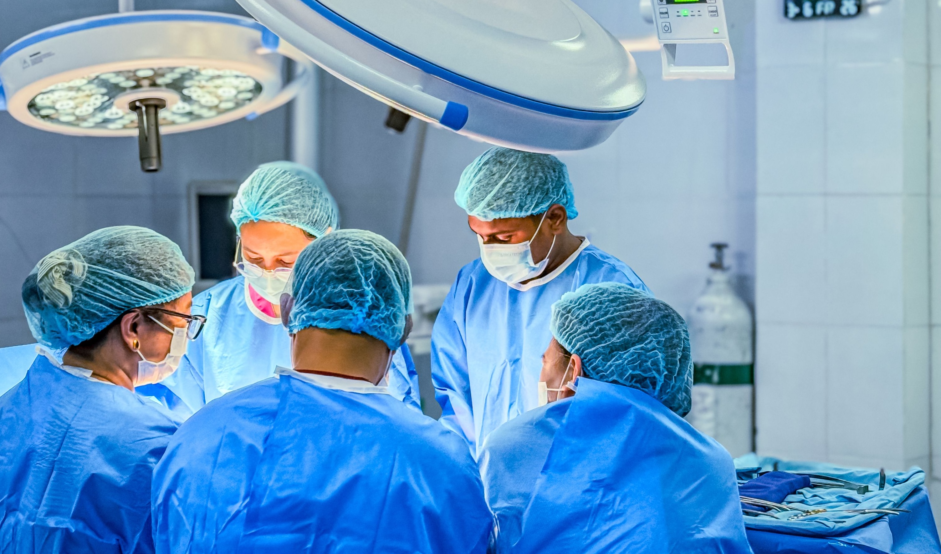 Surgical team in blue scrubs operating in a hospital theatre equipped by Vannin Group