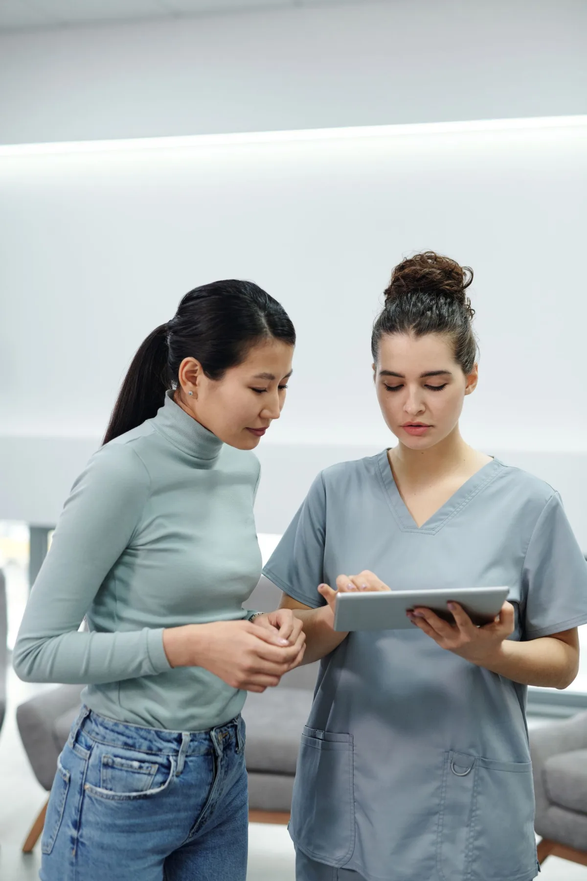 A clinician and a patient looking at a tablet computer.