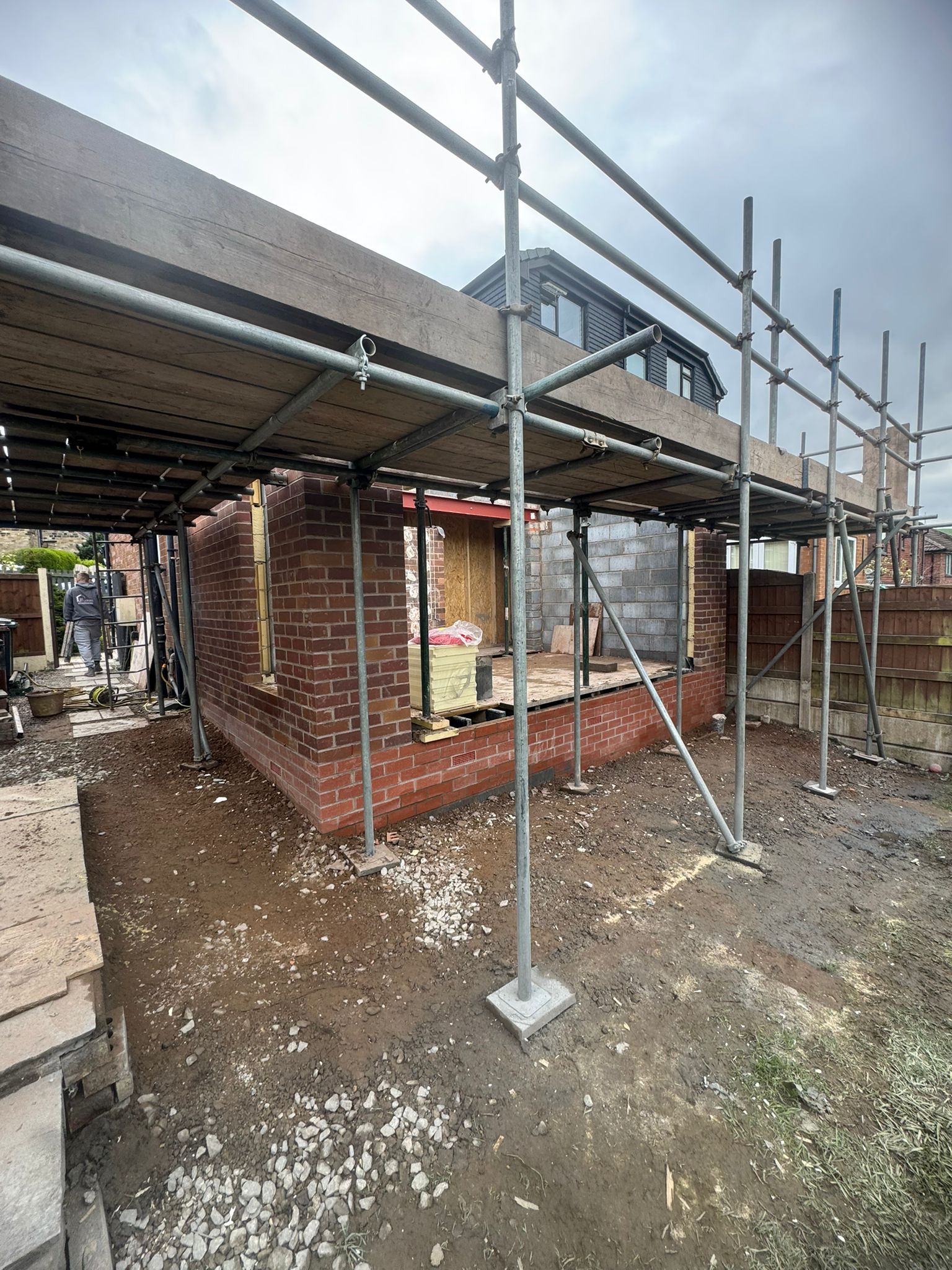 Brickwork house extension under construction with scaffolding at residential property in Cheshire