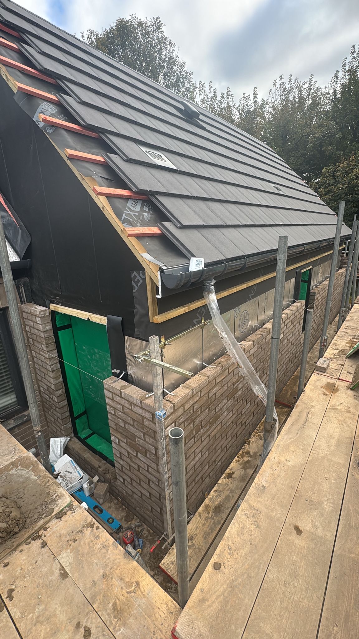 Building renovation with brickwork and roofing installation in Glossop