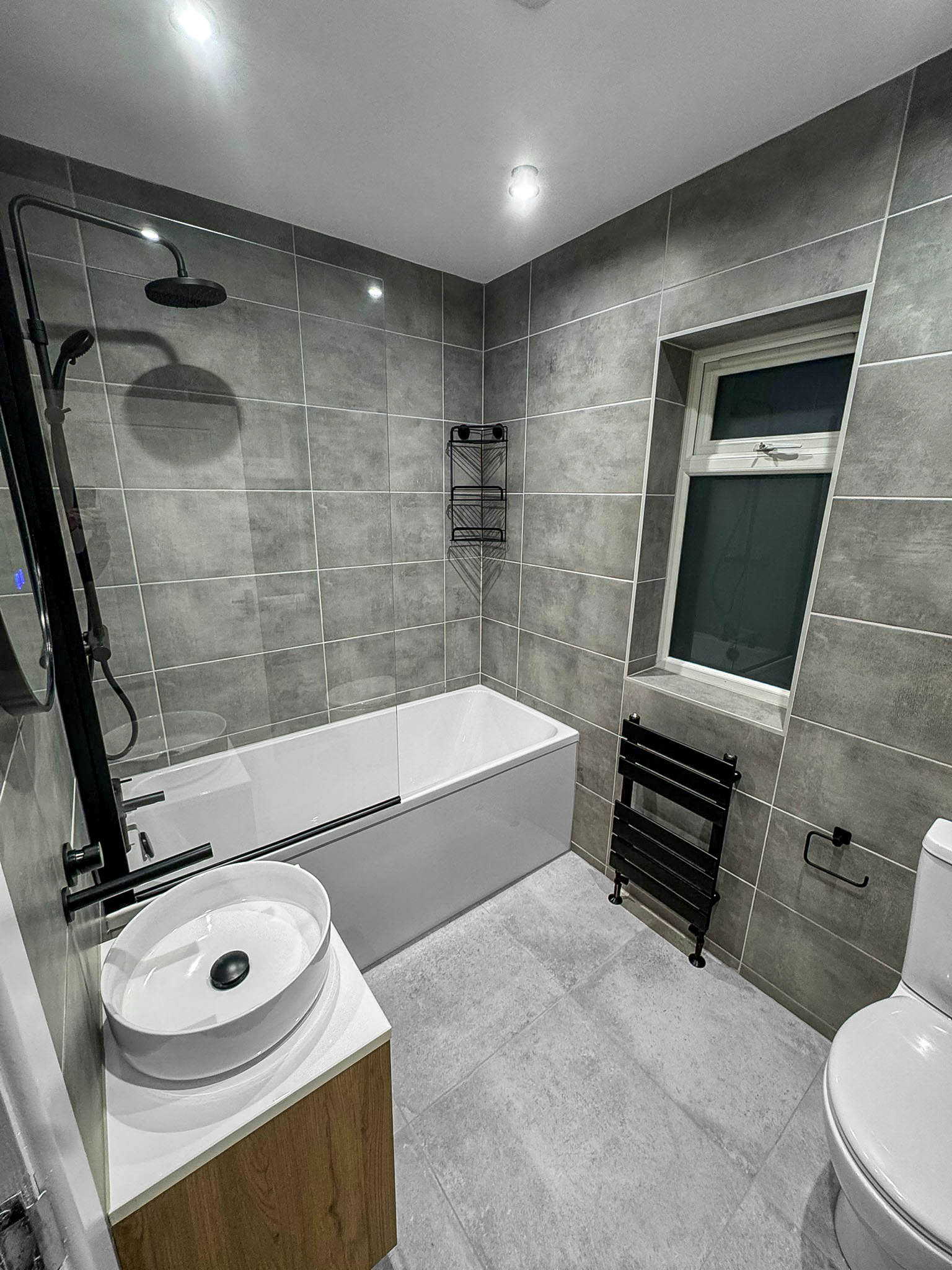 Bathroom renovation with modern tiling and bath installation in Greater Manchester