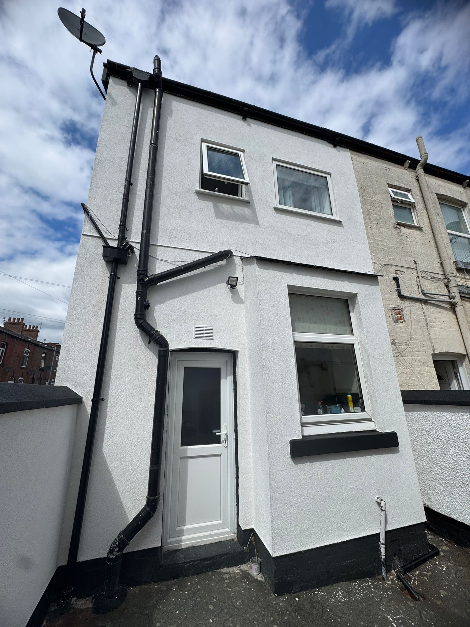Exterior rendering and guttering installation on residential property in Glossop
