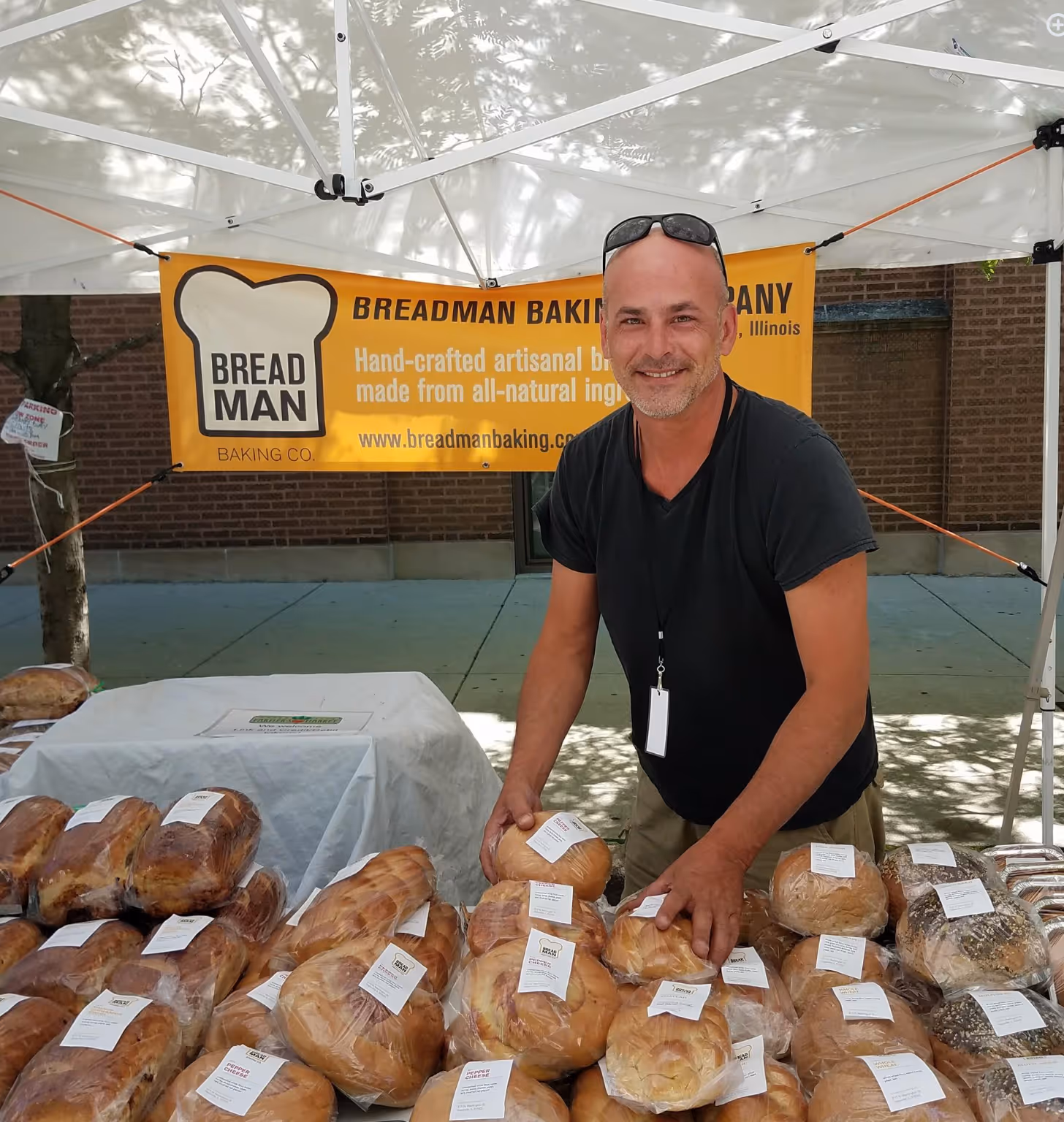 Image of the Breadman at his farmers market booth selling bread.