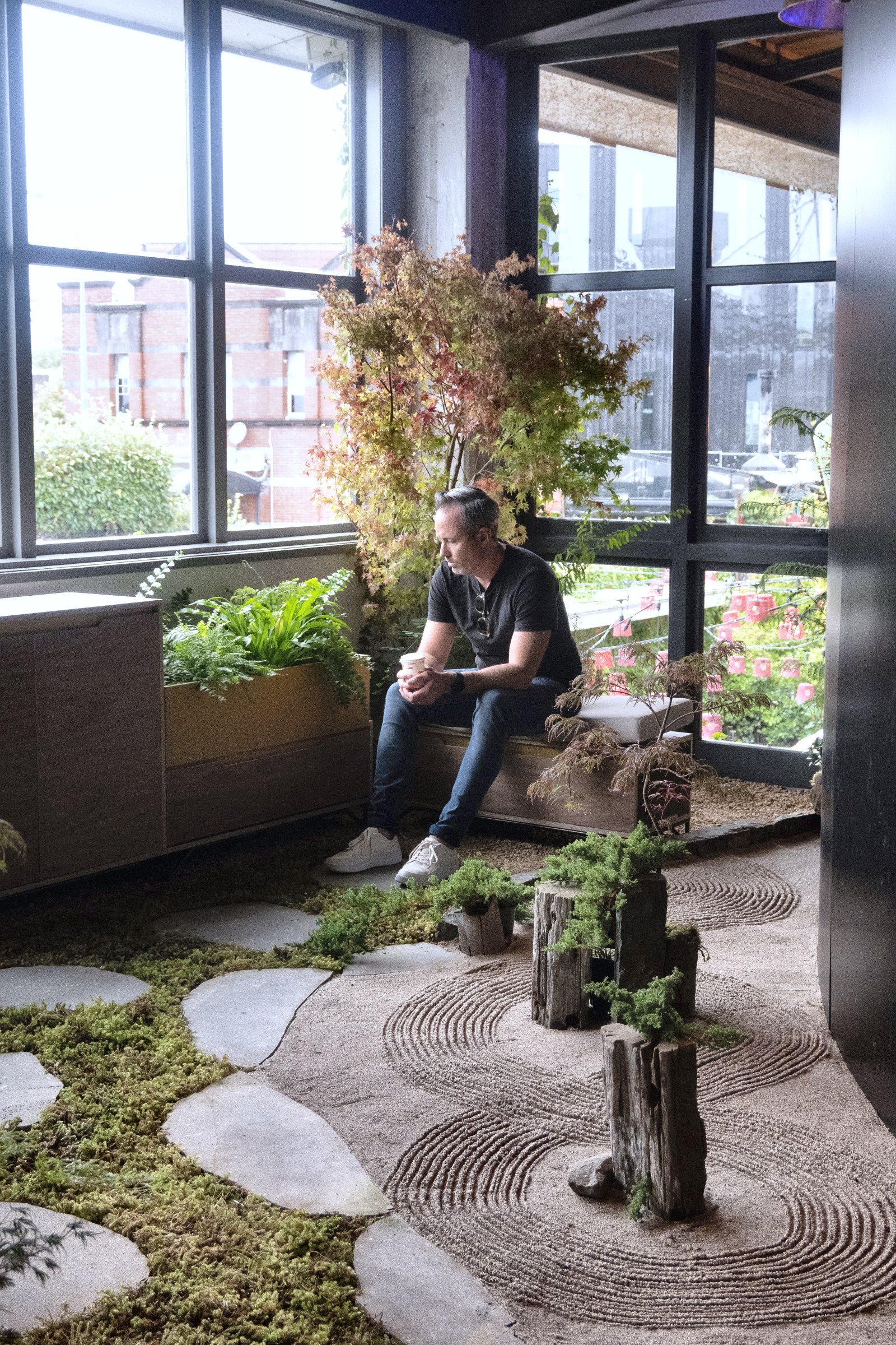 Visitor relaxing on a bench in GreenAir's indoor garden at Auckland Design Week 2024