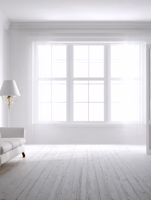 Bright, minimalist white room with large window, white curtains, a white sofa on the left, and a floor lamp.