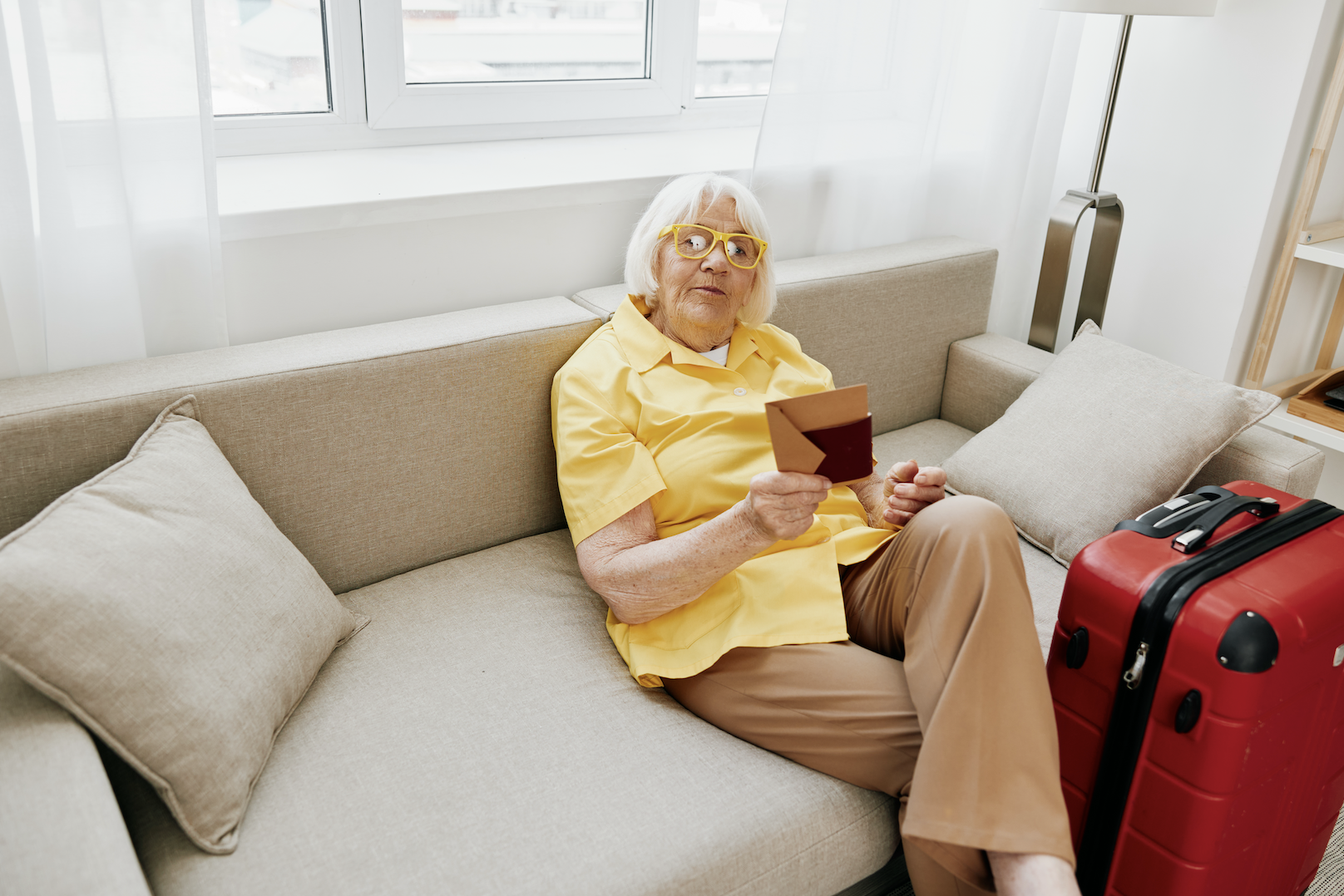 A older lady sitting in a lounge holding a card