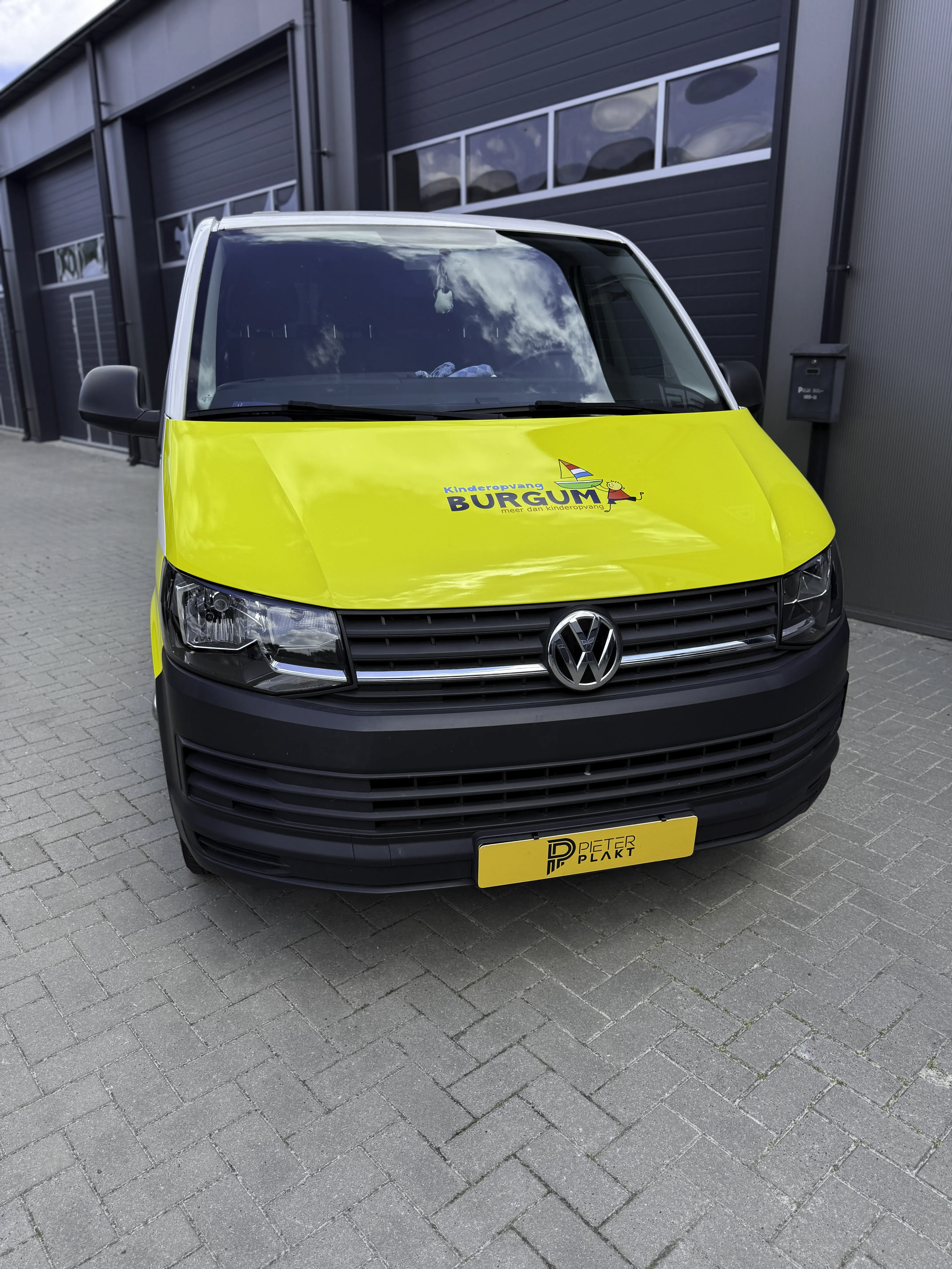 Volkswagen Transporter met full colour belettering voor Kinderopvang Burgum, vooraanzicht