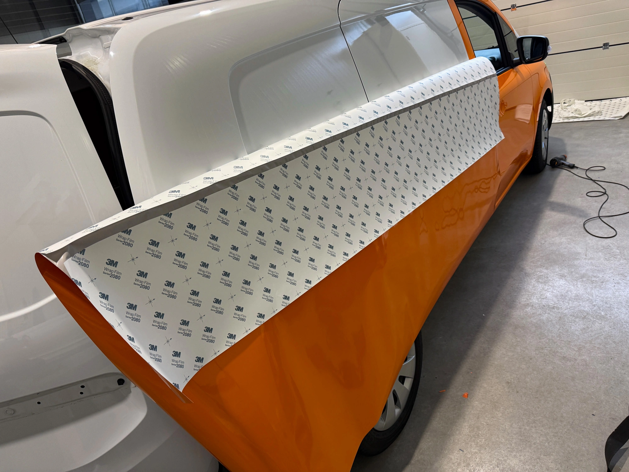 Het aanbrengen van de wrapfolie op de Mercedes eCitan in de werkplaats van Pieter Plakt