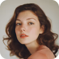 Close-up portrait of a young woman with wavy brown hair and neutral expression on a light background.