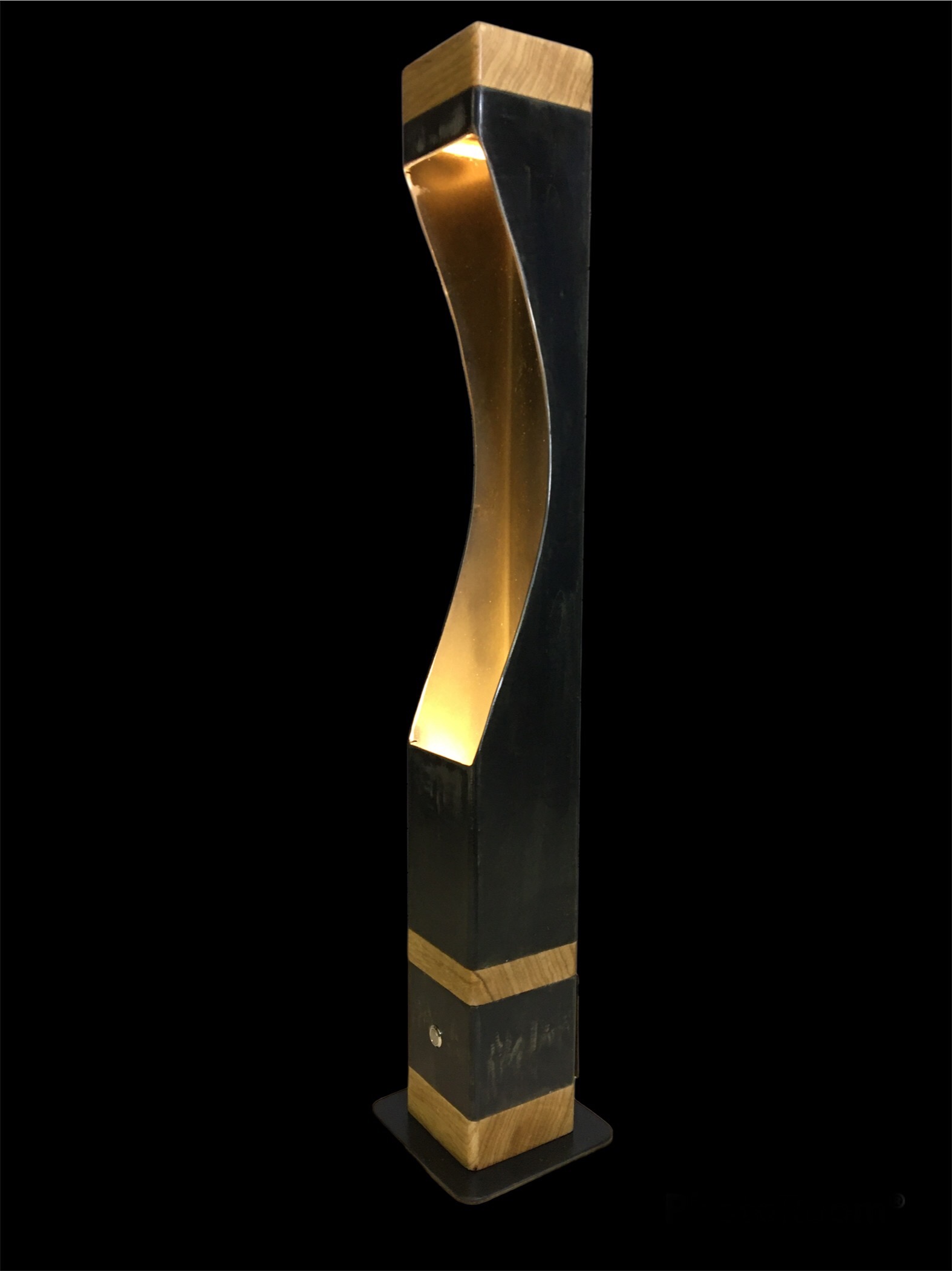 Lampe moderne sur pied en bois et métal avec lumière douce intérieure, fond noir.