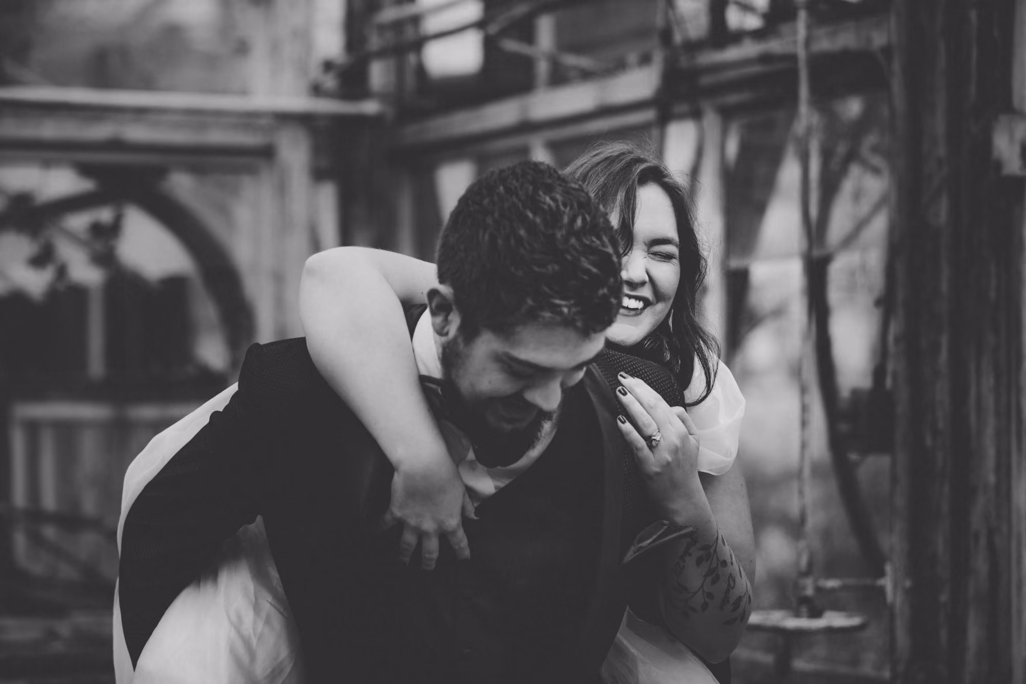 Un couple heureux partage un moment joyeux et intime dans un décor industriel, leur bonheur captivant dans un cliché