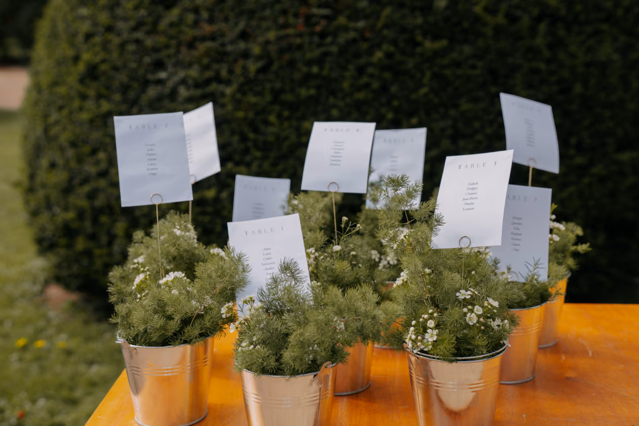 Tableau de table avec des pots en cuivre et des fleurs blanches, offrant un toucher rustique et élégant pour un mariage