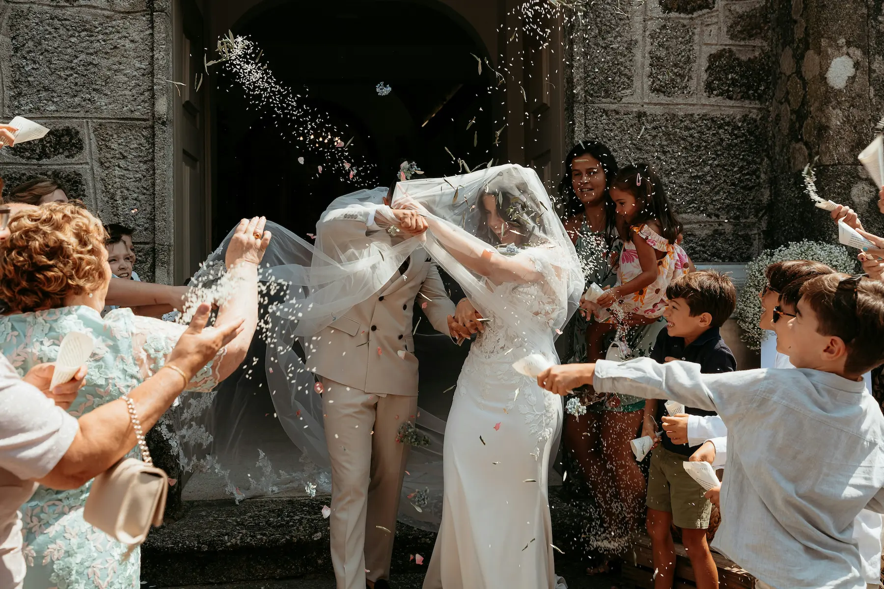 Un couple de mariés se débarrassant de leur cape de mariage, entourés de fous d'explosifs et de confetti, dans une