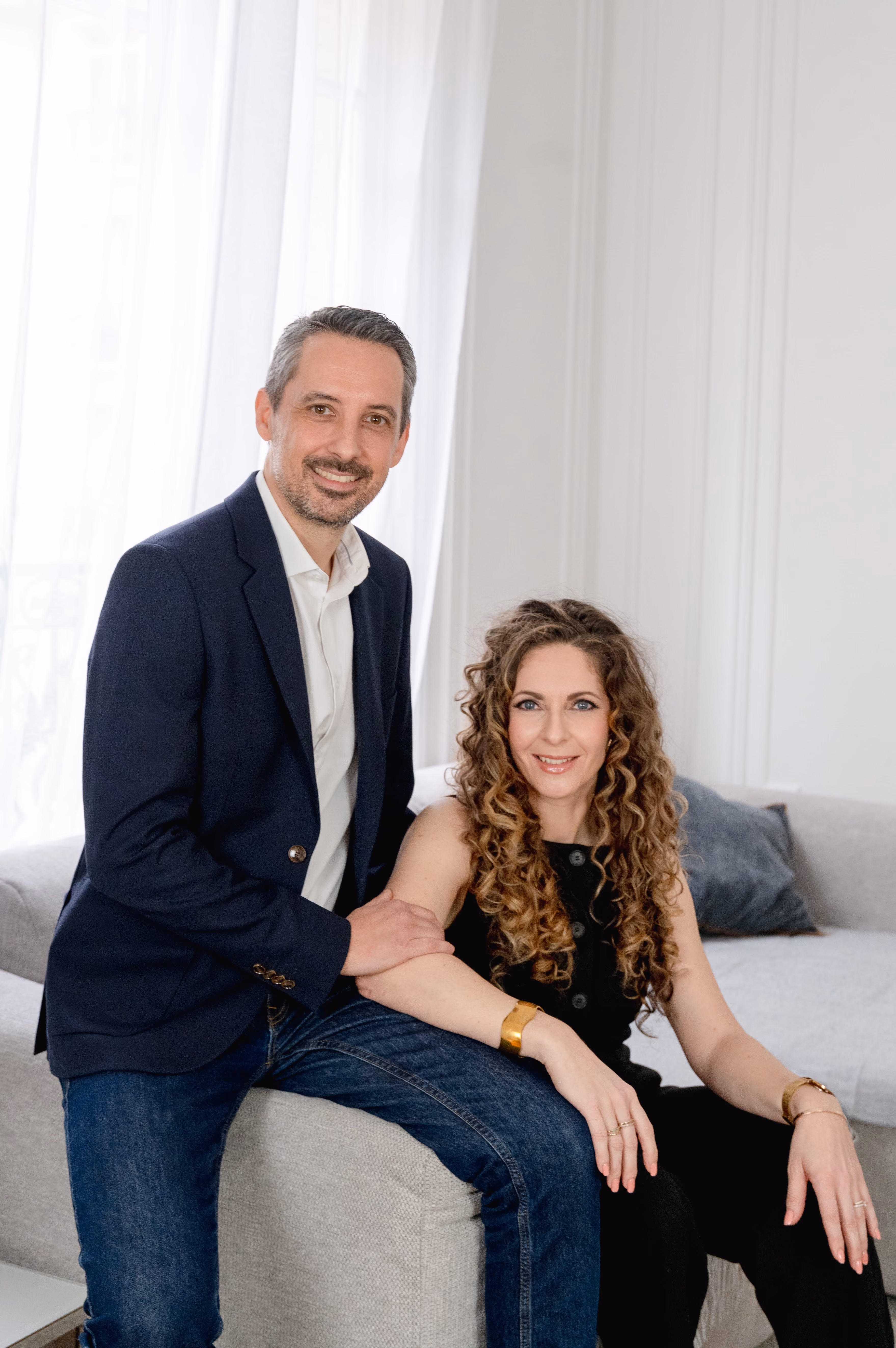 Un couple heureux et élégant dans un salon moderne, prêt à célébrer leur mariage.