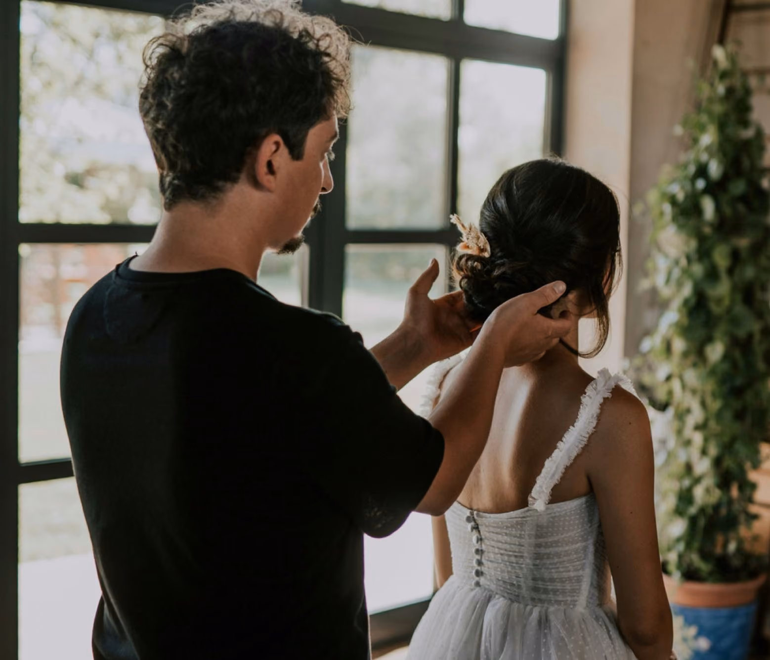 Un couple en amour partage un moment tendre, le mari prépare le mariage de sa future femme, qui porte une robe blanche élégante.
