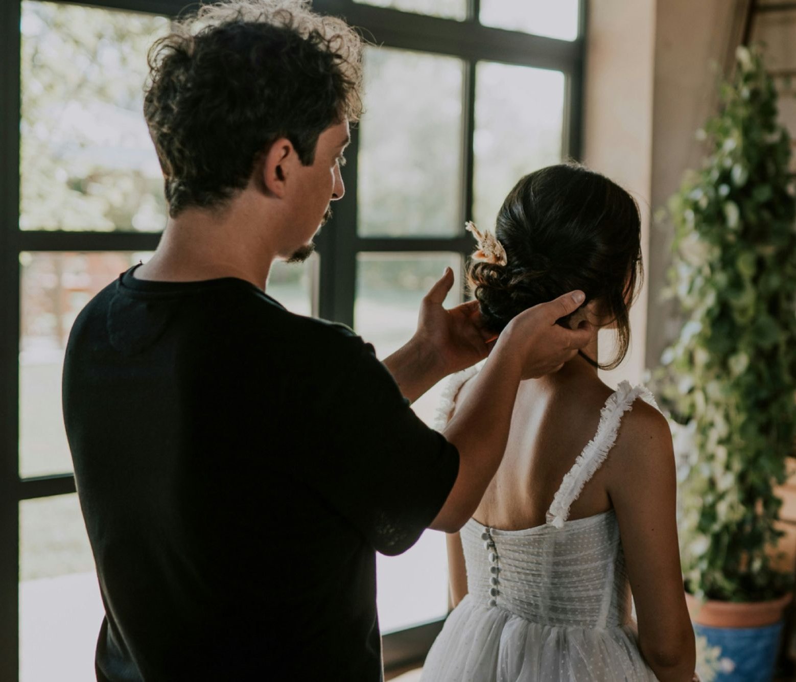 Un couple en amour partage un moment tendre, le mari prépare le mariage de sa future femme, qui porte une robe blanche élégante.