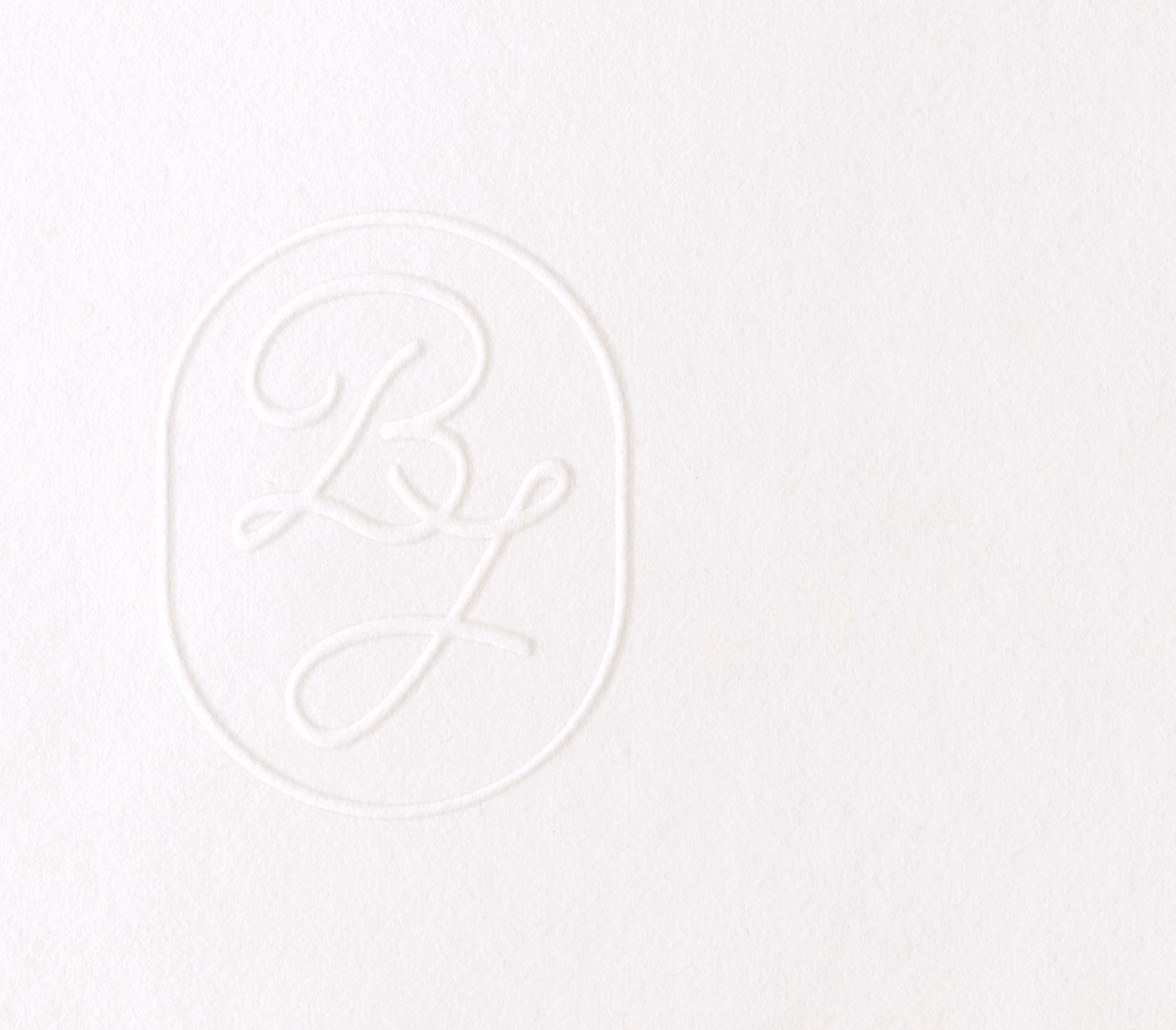 Un monogramme élégant et subtil imprimé sur du papier blanc, idéal pour une invitation de mariage classique.