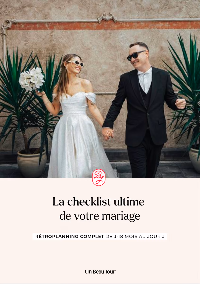 Une jeune mariée heureuse et son mari souriant dans un décor romantique, promouvant un guide de planification de mariage complet.