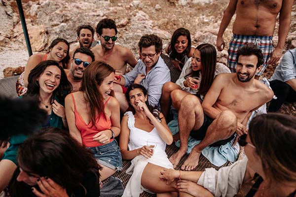 Groupe d'amis souriants et décontractés posant ensemble dans un décor rocheux et naturel.