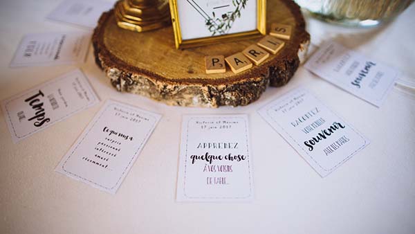 Papeterie de mariage personnalisée et lettres en bois sur un socle en bois brut, ambiance bucolique et romantique.