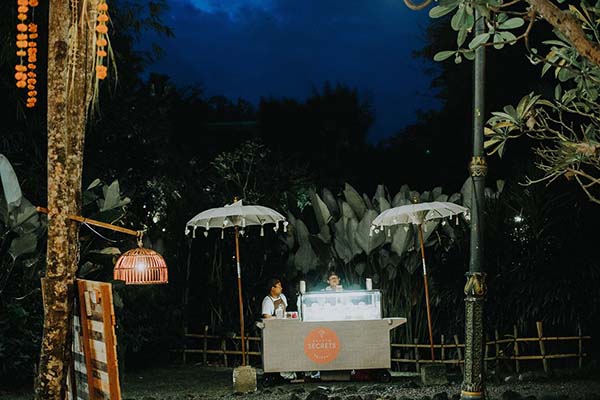 Stand de glaces nocturne sous parasols blancs, ambiance romantique et tamisée lors d'une soirée à Bali.