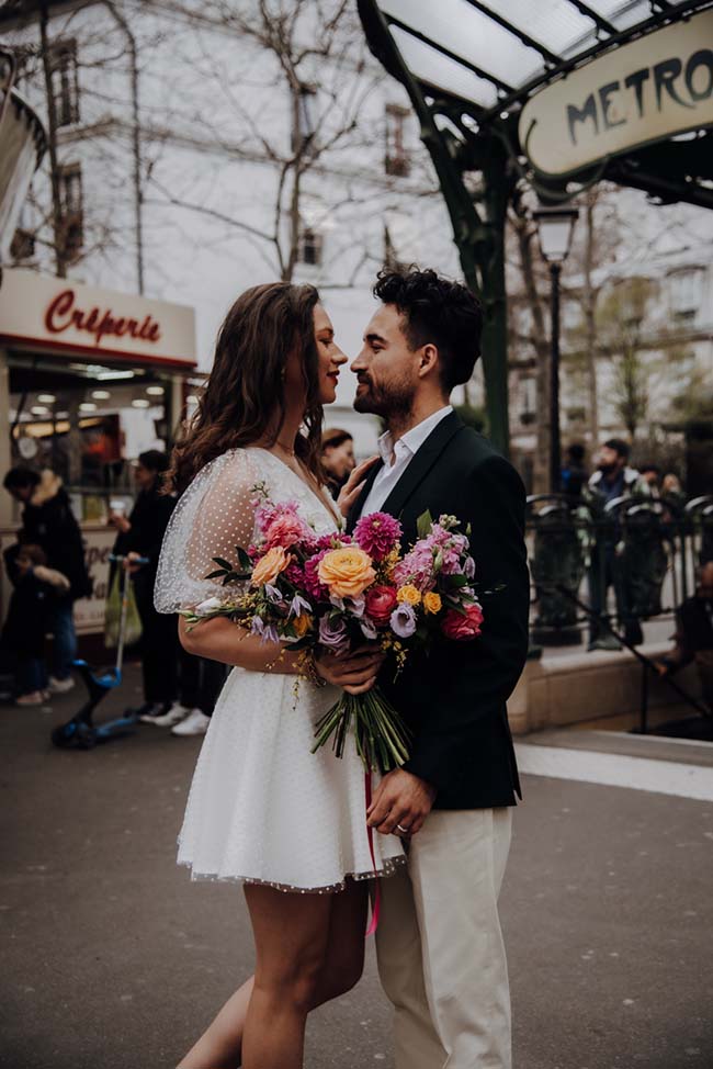 Un couple émerveillé près d'un métro de Paris, célébrant leur elopement romantique.