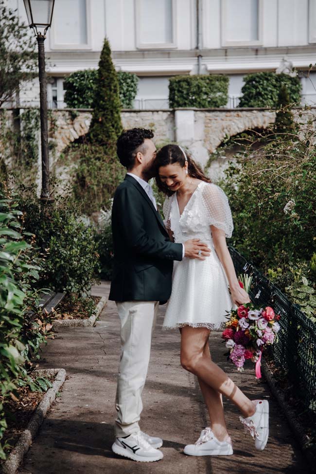 Un couple heureux et romantique se promène dans un jardin charmant, avec la femme portant un bouquet de fleurs colorées