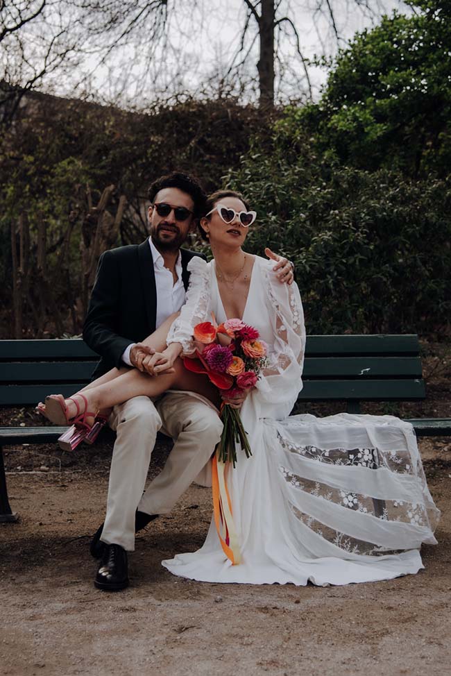 Un couple romantique se détient sur un banc, célébrant leur elopement dans un parc paisible.