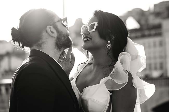 Un couple heureux se regarde l'un l'autre dans les yeux, un homme dans un costume sombre et une femme dans une robe