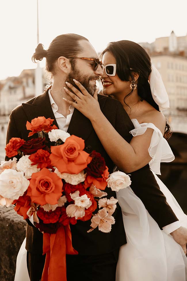Un couple heureux dans des vêtements de mariage urbain chauds, partageant un moment intime avec un bouquet de roses