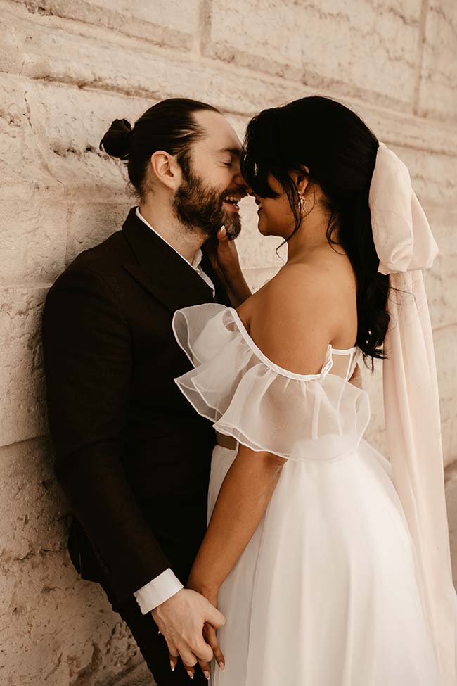 Un couple romantique se penche l'un contre l'autre dans une intimité intime, leurs mains se rejoignant tendrement