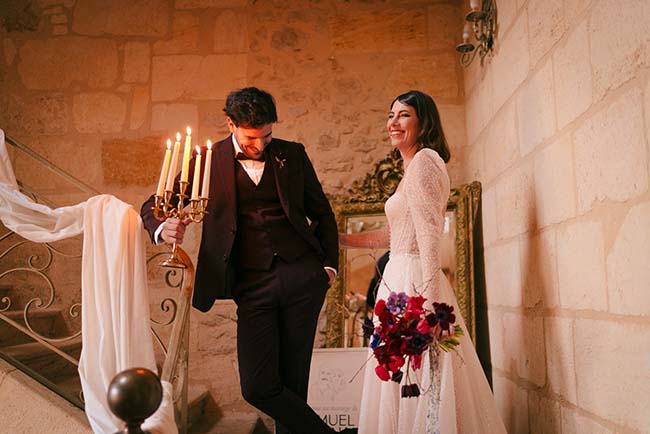 Un couple heureux dans des vêtements de mariage classiques, ambiante chaude et romantique avec un candelabre à huit brûleurs.