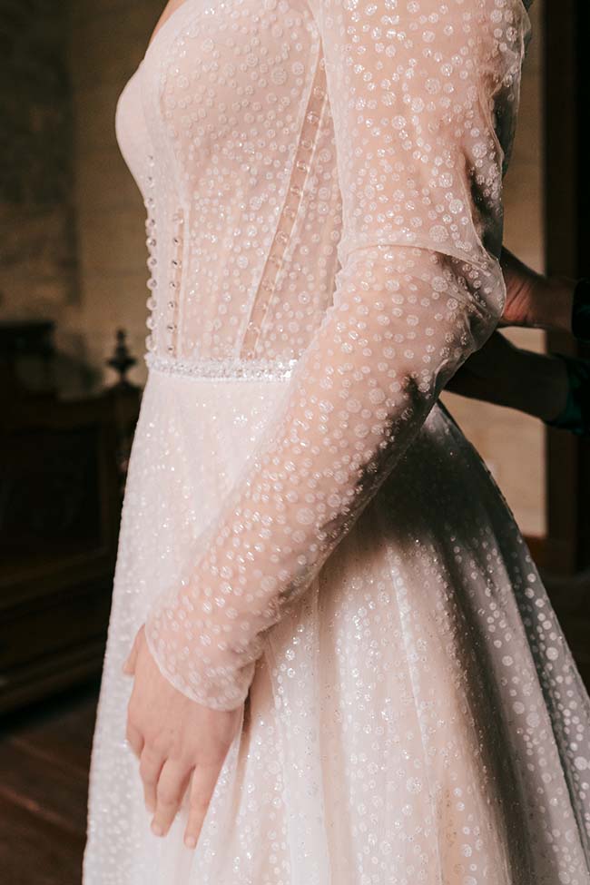 Élégante robe de mariage blanche avec détails en perles, créant un look romantique et sophistiqué.