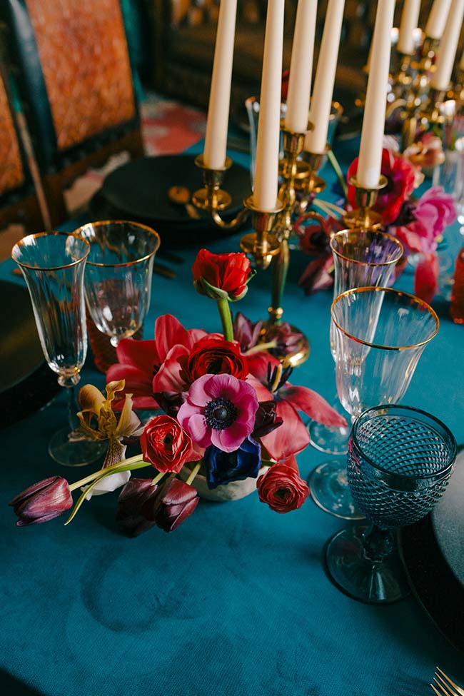 Un banquet d'élégance avec des fleurs vives et des verres soigneusement alignés, évoquant un mariage moderne et animé.
