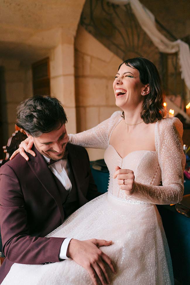 Une mariée rassurée par son mari dans un décor romantique et intime.